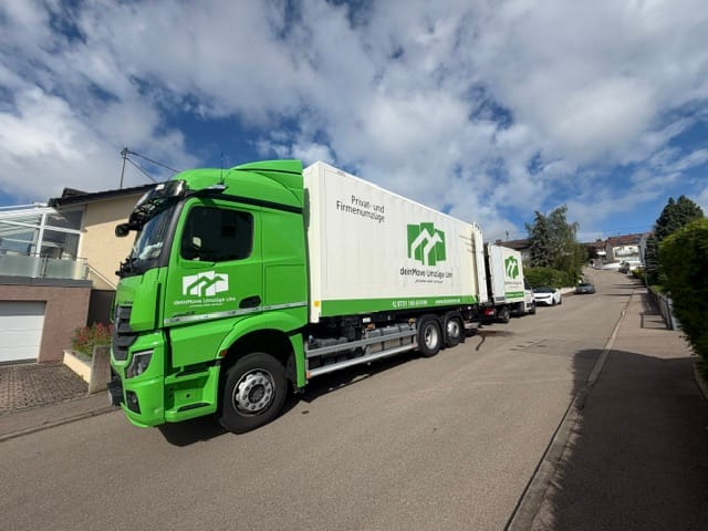 Camion deinMove avec remorque dans une rue résidentielle