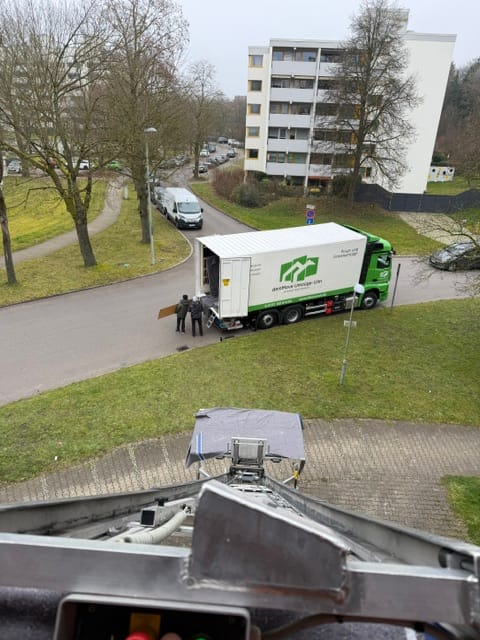 Monte-meubles deinMove en action devant un immeuble